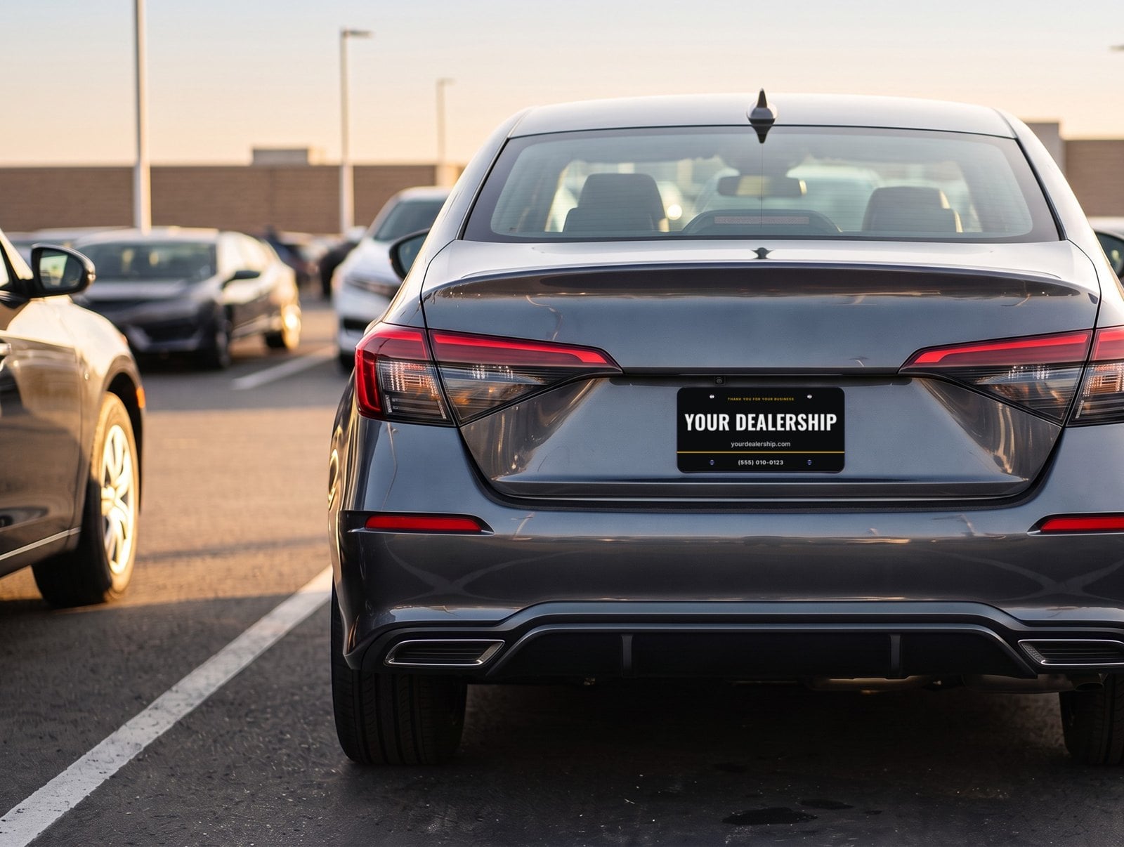 The back of a car on a dealership lot, fitted with a sample Dealer Plate Pro plate reading Your Dealership